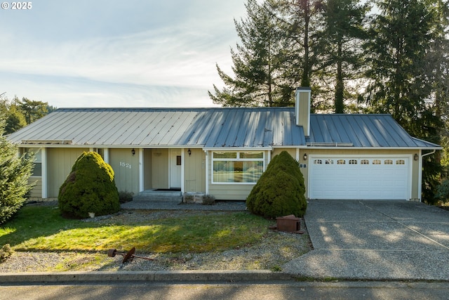 1521 Ranch Rd, Reedsport, OR 97467 - view of front of property featuring a chimney, metal roof, a garage, and driveway