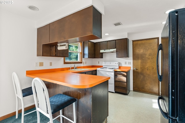 1521 Ranch Rd, Reedsport, OR 97467 - kitchen featuring white electric range oven, freestanding refrigerator, under cabinet range hood, a peninsula, and light countertops