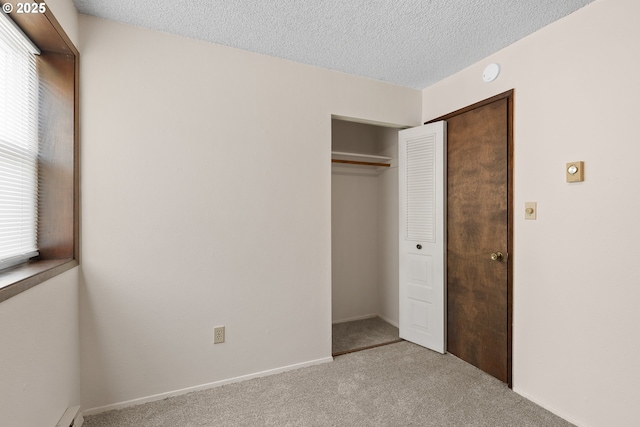 1521 Ranch Rd, Reedsport, OR 97467 - unfurnished bedroom with carpet floors, a closet, a textured ceiling, baseboards, and a baseboard heating unit