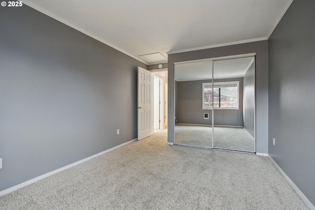 unfurnished bedroom featuring a closet, crown molding, baseboards, and carpet floors