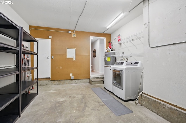 laundry area featuring a garage, separate washer and dryer, secured water heater, and laundry area