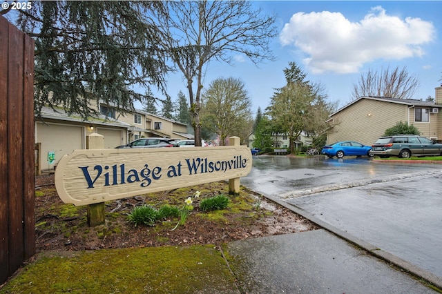 community sign featuring a residential view and driveway