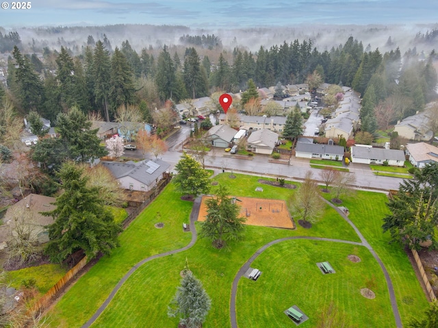 birds eye view of property featuring a residential view and a wooded view