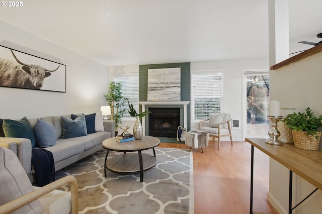 living area with a fireplace with flush hearth and wood finished floors