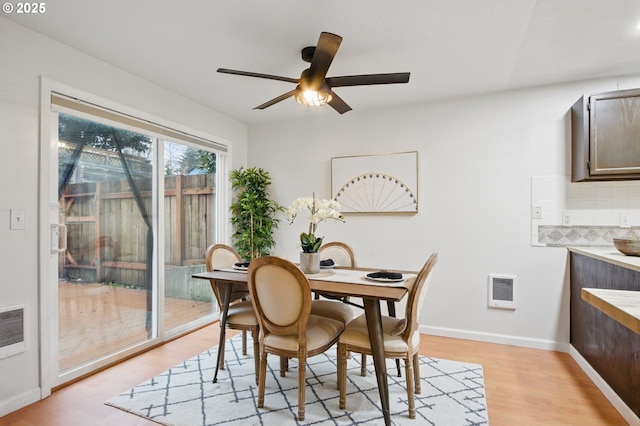 dining space featuring a ceiling fan, baseboards, and light wood finished floors