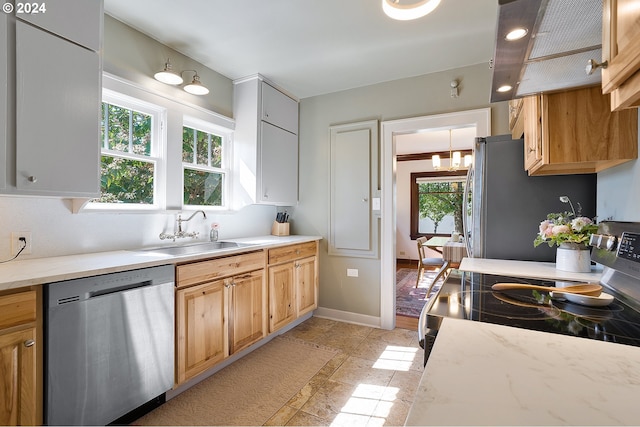 7516 N Brandon Ave, Portland, OR 97217 - kitchen with stainless steel appliances, a sink, baseboards, light stone finish floors, and light stone countertops