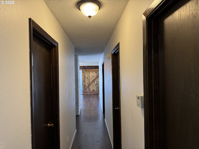 404 NE High St, Goldendale, WA 98620 - corridor with dark wood-style floors, a textured ceiling, and baseboards