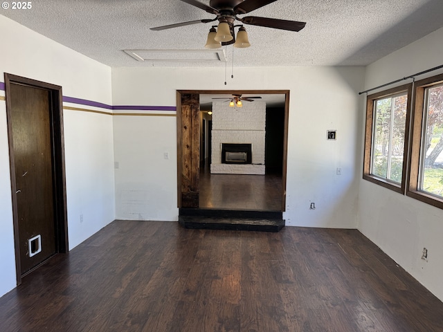 404 NE High St, Goldendale, WA 98620 - spare room with a ceiling fan, a textured ceiling, wood finished floors, and a fireplace