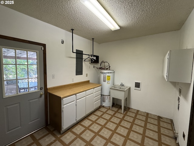 404 NE High St, Goldendale, WA 98620 - washroom featuring electric water heater, light floors, cabinet space, electric panel, and a textured ceiling