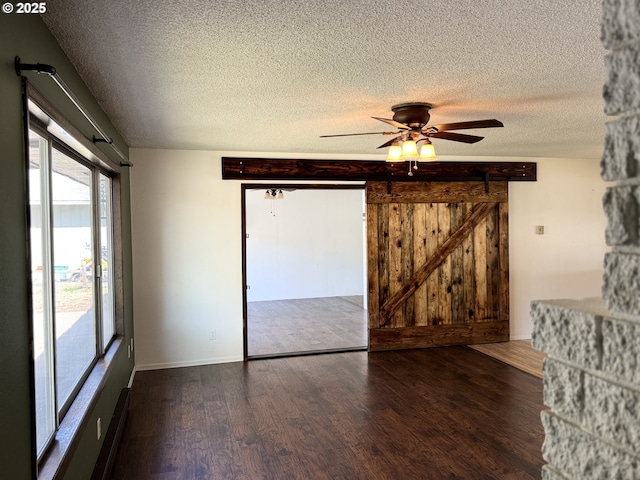 404 NE High St, Goldendale, WA 98620 - empty room featuring wood finished floors, a barn door, a textured ceiling, and a ceiling fan