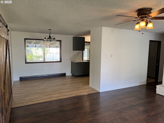 404 NE High St, Goldendale, WA 98620 - unfurnished living room with baseboard heating, a chandelier, a textured ceiling, dark wood-style flooring, and plenty of natural light