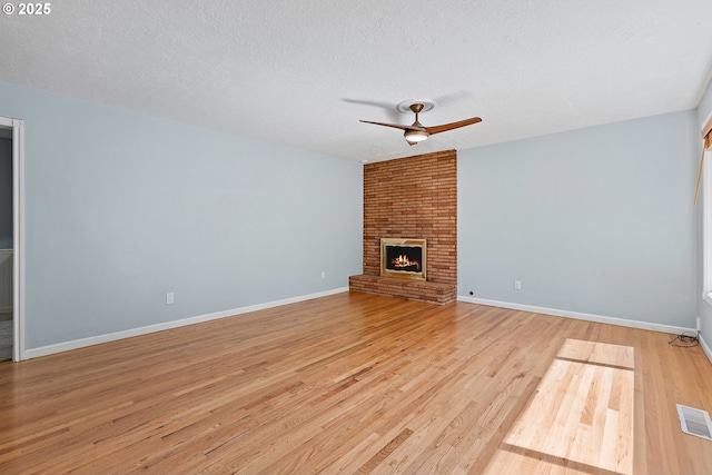 16880 Tracy Ave, Lake Oswego, OR 97035 - unfurnished living room featuring ceiling fan, light wood-style floors, a textured ceiling, and a brick fireplace
