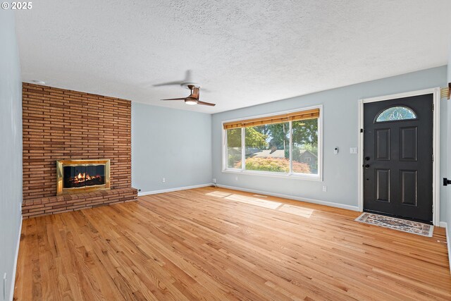16880 Tracy Ave, Lake Oswego, OR 97035 - unfurnished living room with a textured ceiling, light wood-style flooring, a ceiling fan, and a fireplace