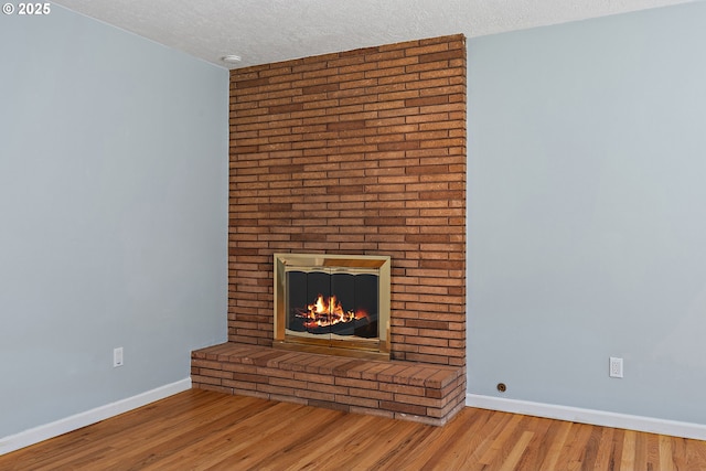 16880 Tracy Ave, Lake Oswego, OR 97035 - unfurnished living room with a brick fireplace, a textured ceiling, and wood finished floors