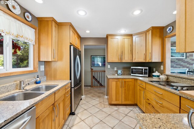 93975 Bridge View Ln, North Bend, OR 97459 - kitchen with appliances with stainless steel finishes, a sink, light stone countertops, light tile patterned floors, and recessed lighting