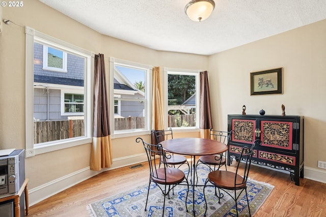 5018 N Vanderbilt St, Portland, OR 97203 - dining room featuring light wood-style flooring and a textured ceiling