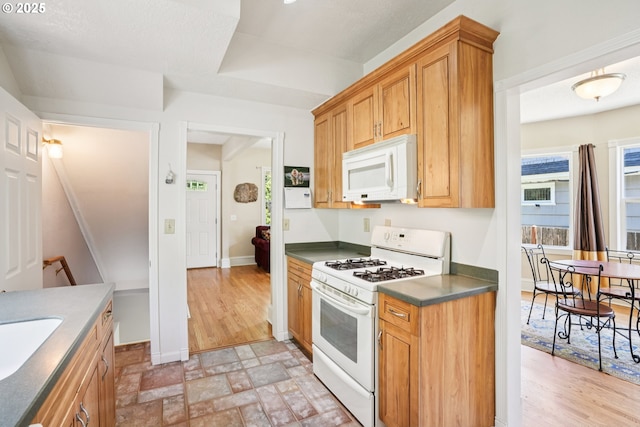 5018 N Vanderbilt St, Portland, OR 97203 - kitchen featuring white appliances, dark countertops, and light stone finish flooring