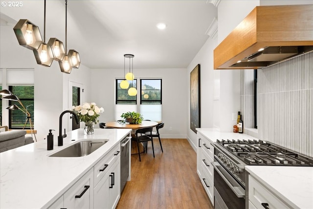 3653 Maidenhair Pl S, Salem, OR 97302 - kitchen featuring wall chimney range hood, a sink, pendant lighting, light wood-style flooring, and appliances with stainless steel finishes