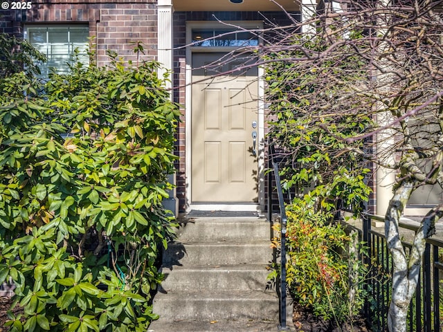 entrance to property featuring brick siding