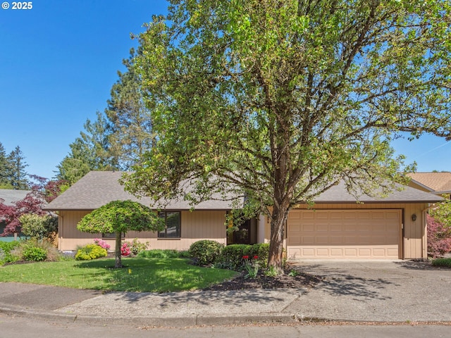 ranch-style home featuring a shingled roof, an attached garage, driveway, and a front lawn