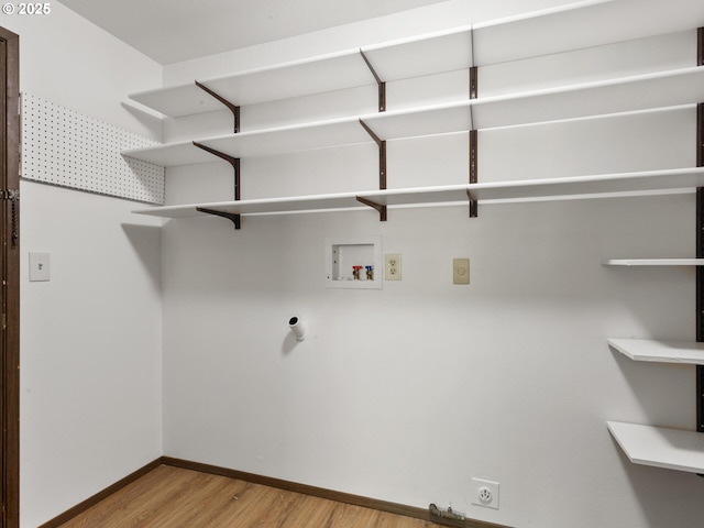 laundry area with washer hookup, laundry area, baseboards, electric dryer hookup, and wood finished floors