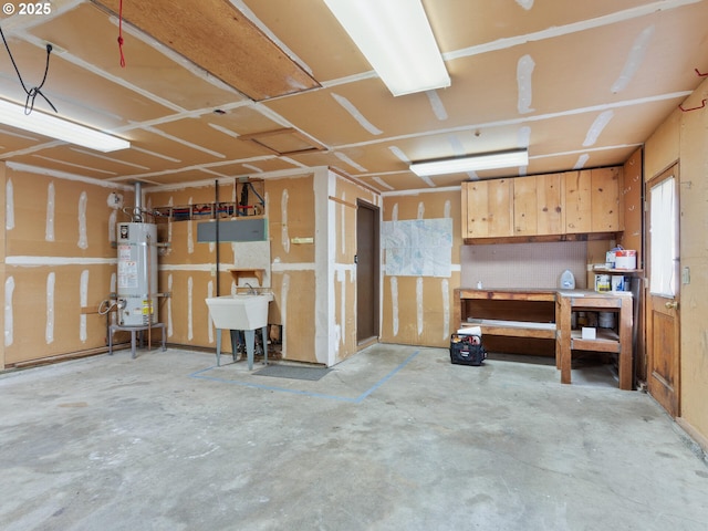 garage with water heater, a workshop area, and a sink