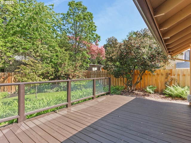 wooden terrace with a fenced backyard