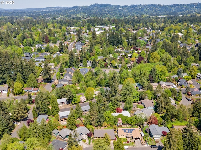 drone / aerial view featuring a residential view and a view of trees