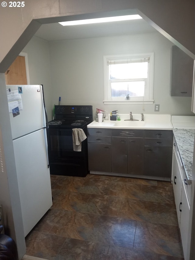 kitchen featuring electric range, sink, and white fridge