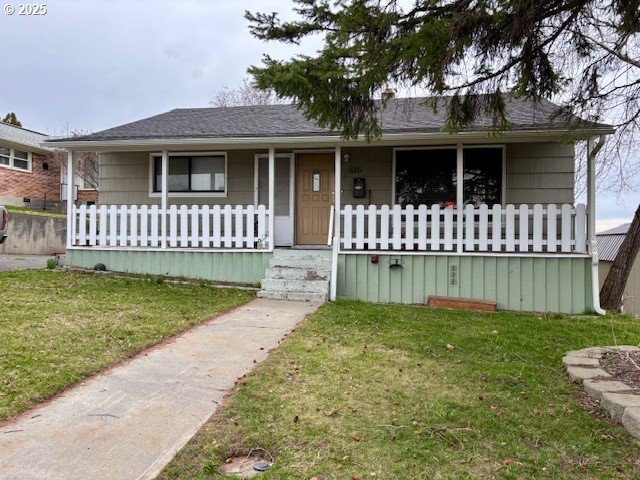 view of front facade with covered porch and a front yard