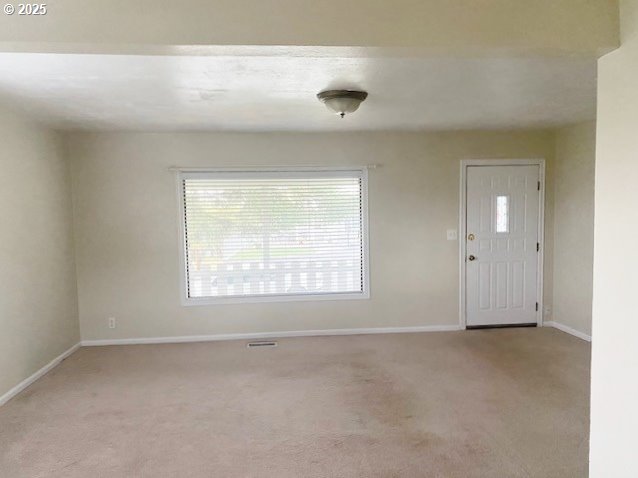 carpeted entryway featuring visible vents and baseboards