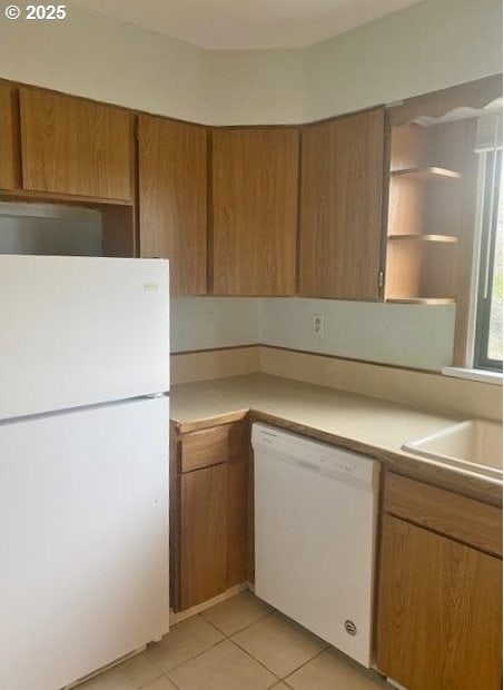 kitchen with light countertops, light tile patterned floors, brown cabinetry, white appliances, and open shelves