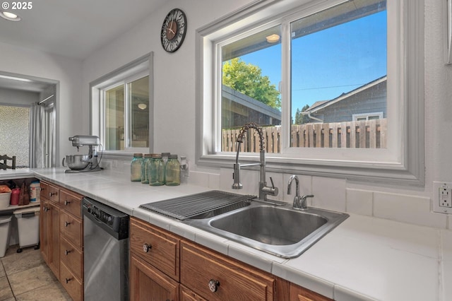 52396 SW 2nd St, Scappoose, OR 97056 - kitchen with stainless steel dishwasher, a sink, brown cabinetry, tile countertops, and recessed lighting