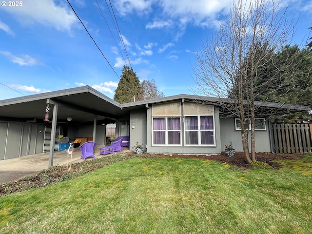 exterior space featuring a carport, a lawn, and fence