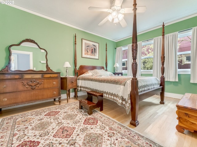 bedroom featuring wood finished floors, ornamental molding, baseboards, and a ceiling fan