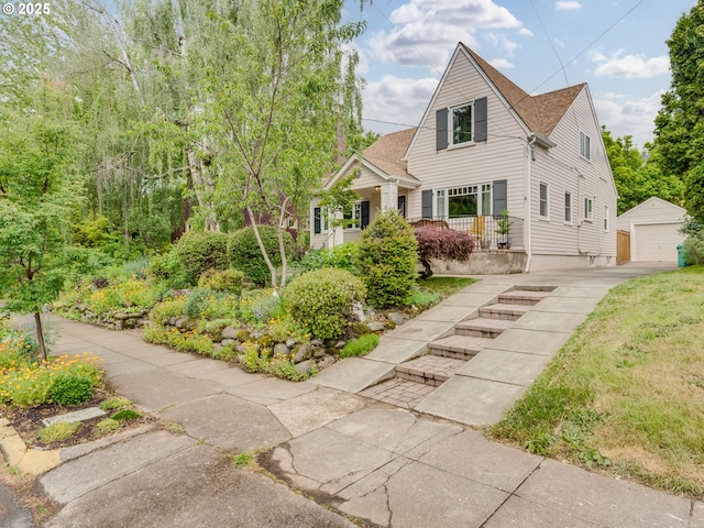 4415 SE Stark St, Portland, OR 97215 - view of front of property featuring a detached garage, an outbuilding, driveway, and roof with shingles
