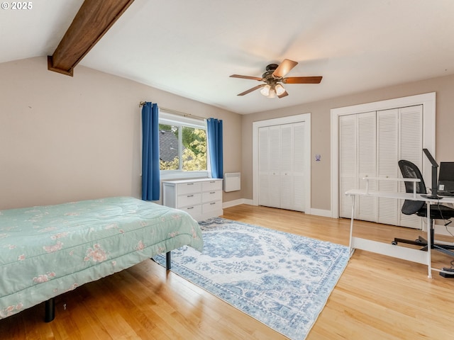 bedroom with multiple closets, wood finished floors, beam ceiling, baseboards, and ceiling fan