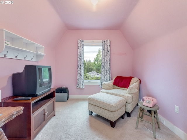 sitting room with vaulted ceiling, light carpet, and baseboards
