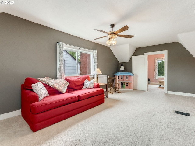 carpeted living area with lofted ceiling, ceiling fan, and baseboards