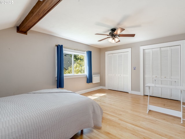 4415 SE Stark St, Portland, OR 97215 - bedroom with light wood-type flooring, two closets, beam ceiling, and ceiling fan
