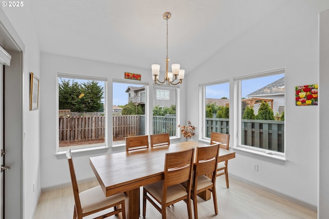 822 Spyglass Dr, Bandon, OR 97411 - dining area featuring a chandelier, light wood-style floors, and vaulted ceiling