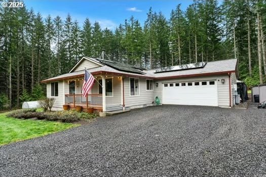 view of front facade with solar panels, a porch, and a garage