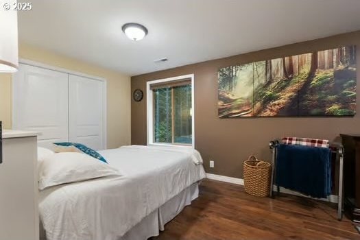 bedroom with dark hardwood / wood-style flooring and a closet