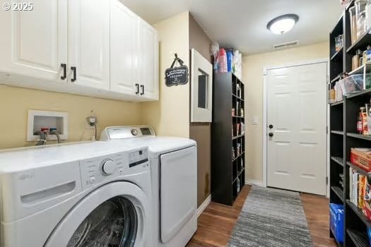 washroom featuring cabinets, dark hardwood / wood-style flooring, and washing machine and dryer