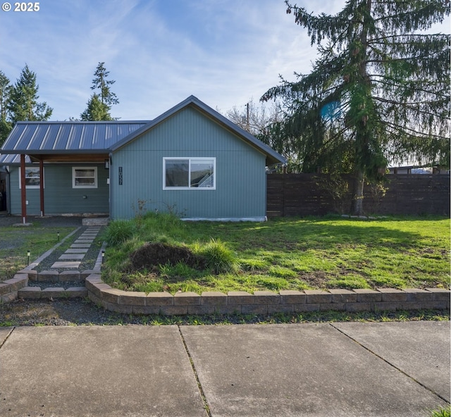 view of front facade featuring a front yard, fence, and metal roof