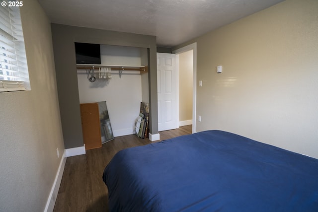 bedroom with baseboards and wood finished floors