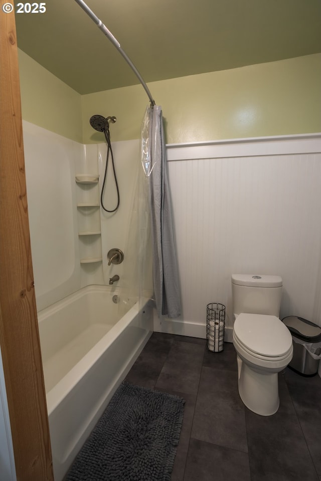 full bathroom with tile patterned flooring, toilet, a wainscoted wall, and shower / tub combo with curtain