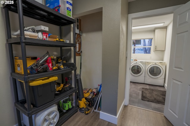 laundry room with wood finished floors, baseboards, a textured wall, laundry area, and washing machine and dryer