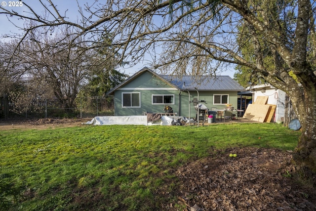 rear view of house featuring a patio area, metal roof, a yard, and fence