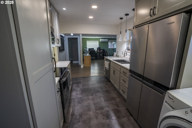 kitchen featuring washer / dryer, stainless steel appliances, light countertops, and a sink